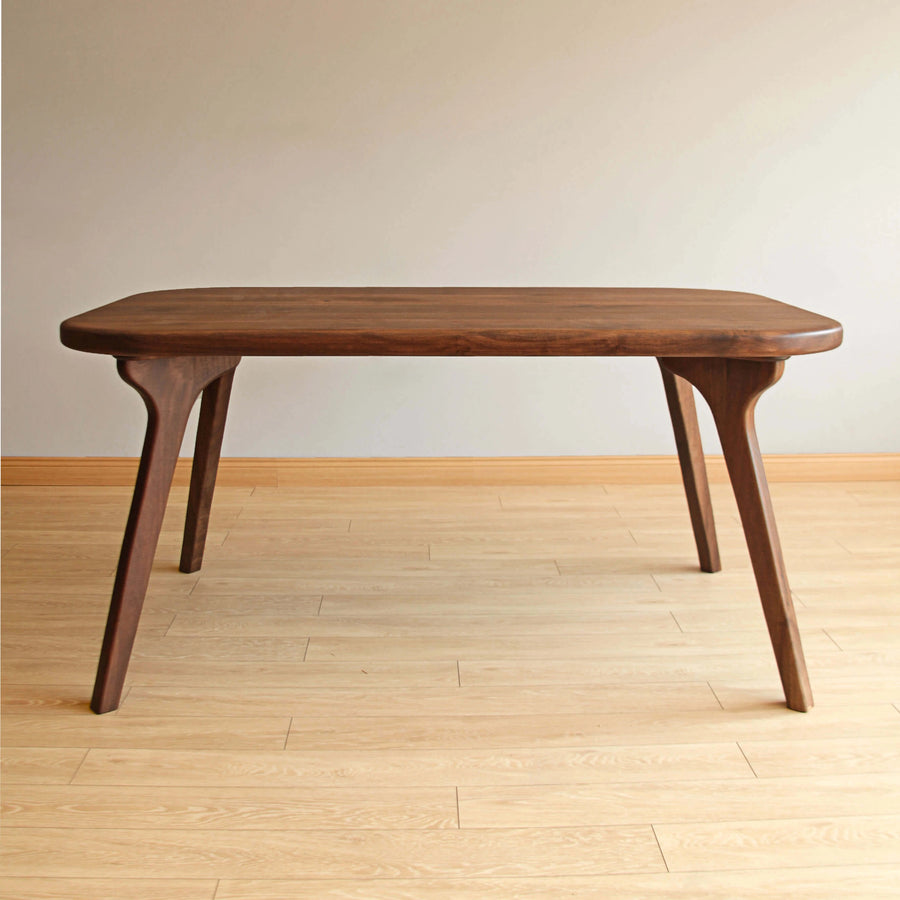 atural lighting emphasizing the warm tones and sleek lines of the hardwood dining table.