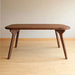 atural lighting emphasizing the warm tones and sleek lines of the hardwood dining table.