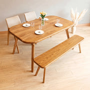 Sidney Rectangle Dining Table Solid Oak Wood – Mid-Century Modern Design with rounded corners, matching bench, and three upholstered chairs in a minimalist room with light wood floors.