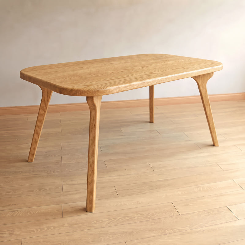 Sidney Rectangle Dining Table Solid Oak Wood – Mid-Century Modern Design with rounded rectangular legs and tapered splayed legs, shown in a minimalist room with light wood flooring and a neutral wall.