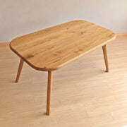 Sidney Rectangle Dining Table Solid Oak Wood – Mid-Century Modern Design with rounded corners and tapered legs, shown on a light wood plank floor against a neutral beige wall.