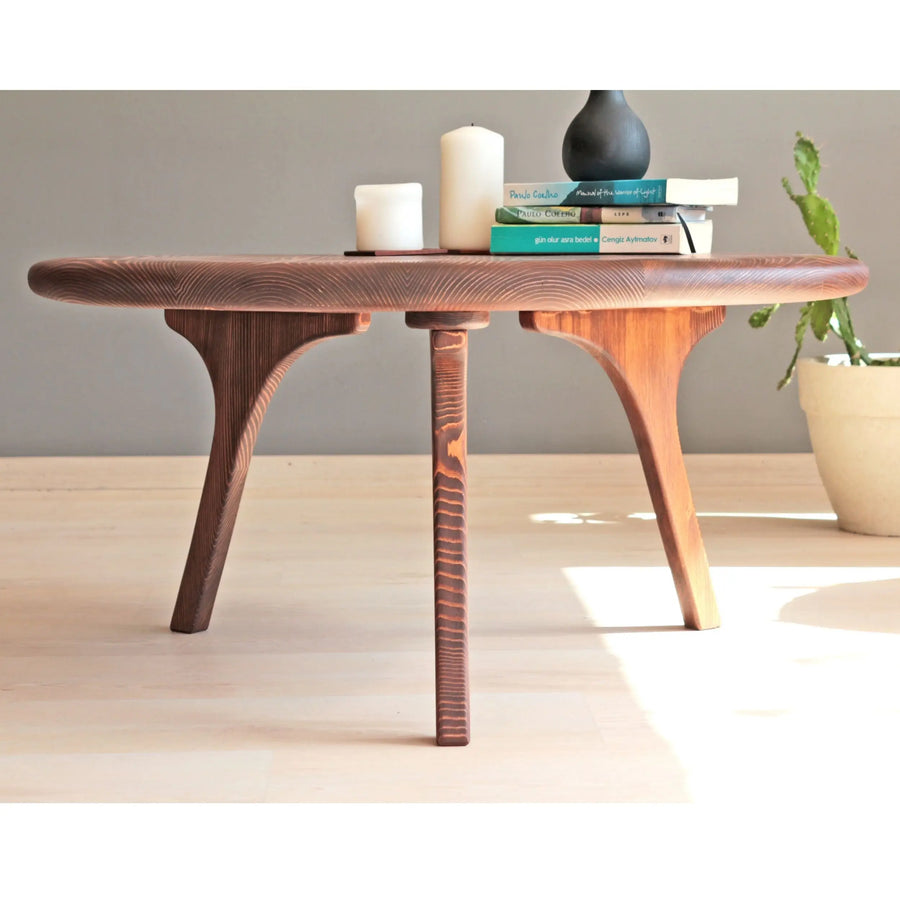 Side view of the round coffee table, focusing on the elegant, minimalistic silhouette and sturdy construction.