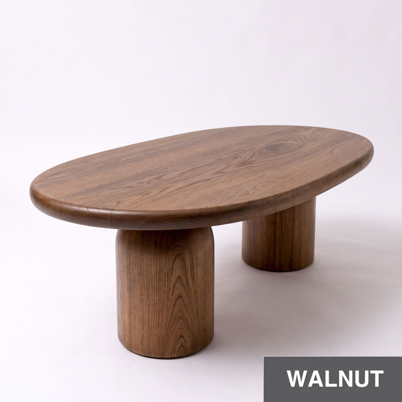 High-angle view of the Solen Oval Coffee Table – Beech Wood Modern Sculptural Design in a rich walnut finish with thick pillar legs.