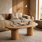 The Solen Oval Solid Wood Coffee Table – Oak & Walnut Sculptural Double Pedestal Design in a natural oak finish styled in an organic modern living room layout.