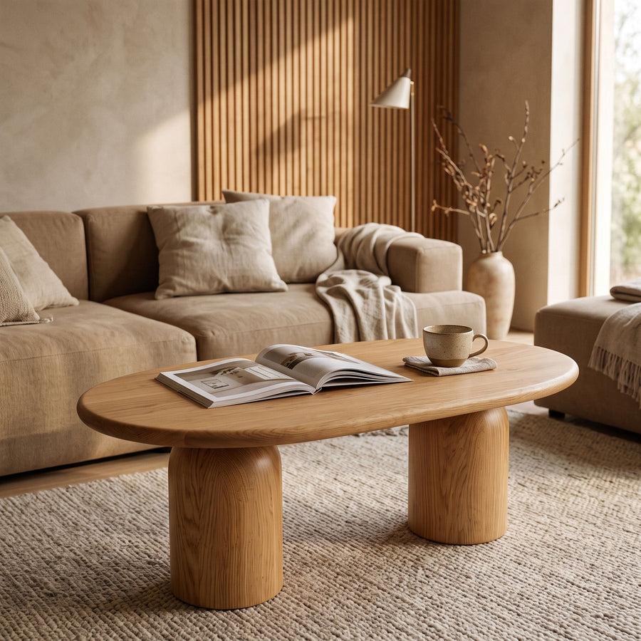 The Solen Oval Solid Wood Coffee Table – Oak & Walnut Sculptural Double Pedestal Design in a natural oak finish styled in an organic modern living room layout.