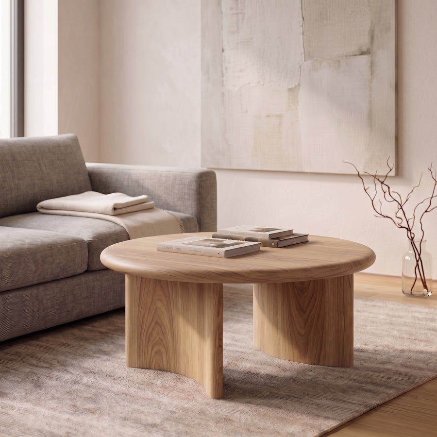 Soren Round Oak Coffee Table | Sculptural Scandinavian Modern Design with chunky block legs in a modern living room setting next to a gray sofa.