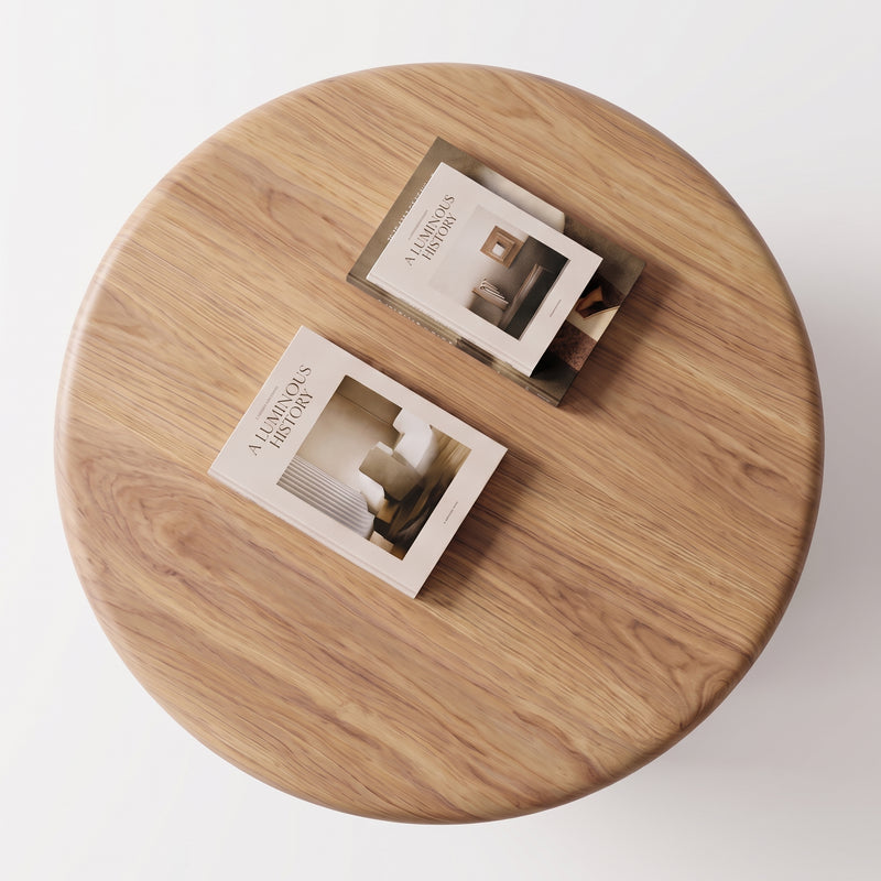 Soren Round Oak Coffee Table | Sculptural Scandinavian Modern Designviewed from above, with two printed brochures or magazines placed on its surface against a clean white background.
