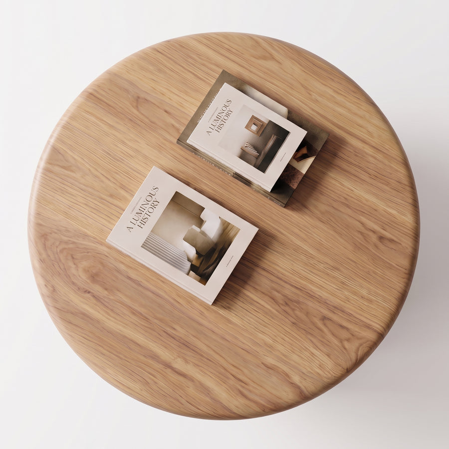 Soren Round Oak Coffee Table | Sculptural Scandinavian Modern Designviewed from above, with two printed brochures or magazines placed on its surface against a clean white background.