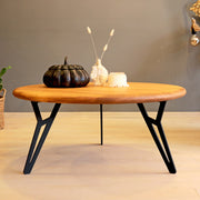 Front view of a solid pine wood round coffee table, showcasing its smooth, natural wood grain and sturdy pedestal base.