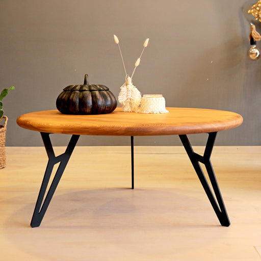 Front view of a solid pine wood round coffee table, showcasing its smooth, natural wood grain and sturdy pedestal base.