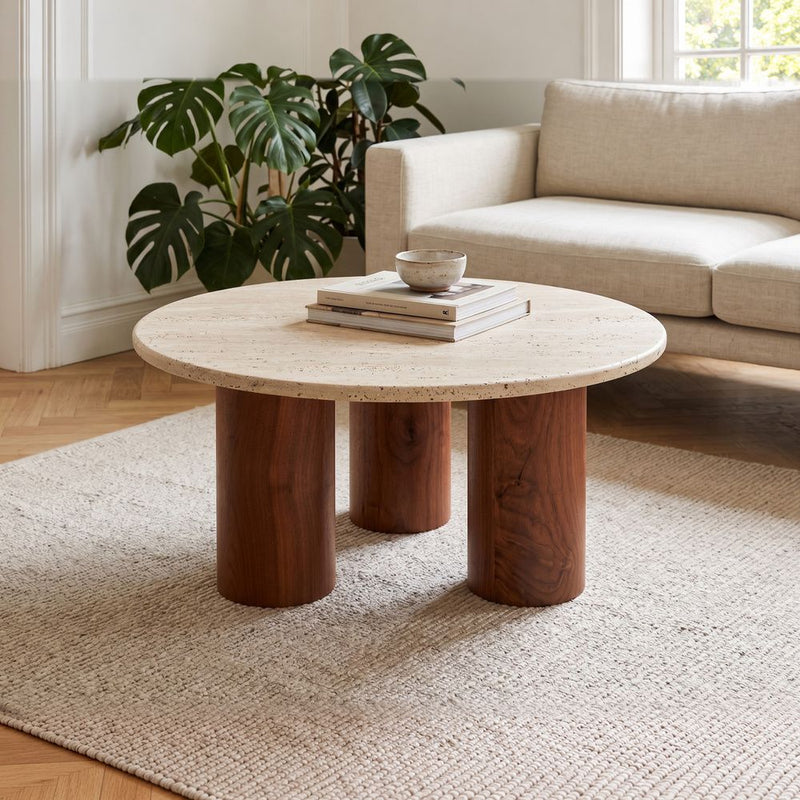 Terra Round Travertine Coffee Table with Walnut Wood Triple Pedestal Base - Sculptural Modern Design Styled in a Bright Living Room by Tomruque