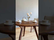 A video showcasing the circular walnut dining table in various settings, emphasizing its design versatility and solid wood craftsmanship.