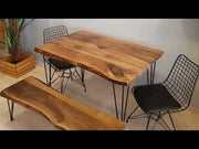 Video showcasing the walnut dining room table from multiple angles, highlighting its live edge design and solid wood construction in a styled setting.