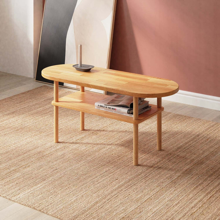 A side view of the Kennard beech wood oval coffee table featuring a minimalist design with smooth lines and a natural wood finish.