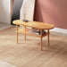 A side view of the Kennard beech wood oval coffee table featuring a minimalist design with smooth lines and a natural wood finish.