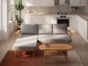 the coffee table placed against a wall with a minimalist design, emphasizing its sleek oval shape and smooth surface.