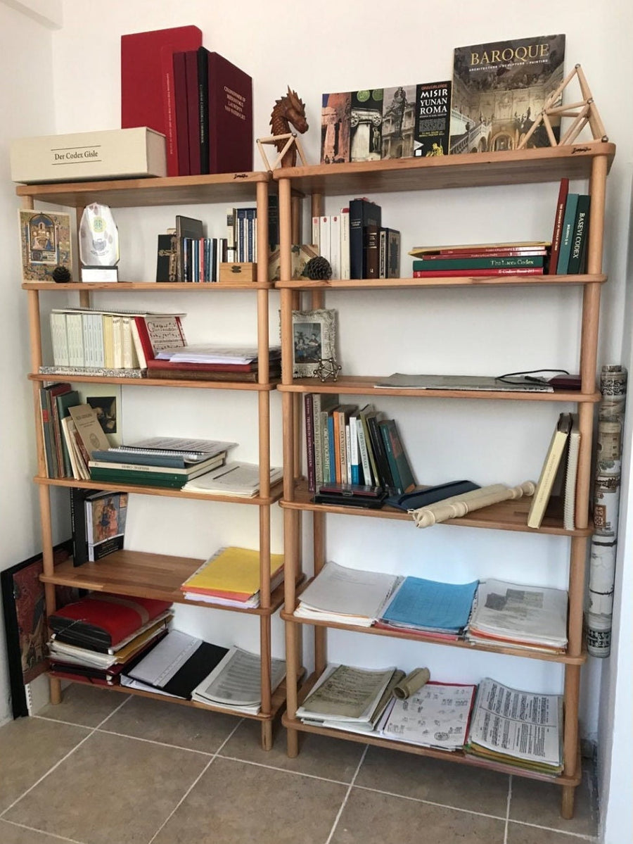  The bookcase styled with a mix of books, plants, and framed photos, demonstrating its versatility.