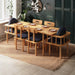 A modern and minimalist rectangular dining table with 6 chairs, set in a well-lit dining room, highlighting the table's sleek and clean lines.