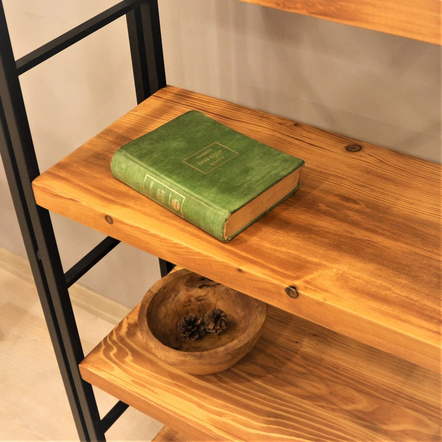 Angled side view of the Stanley Rustic Bookcase, highlighting the slim profile and robust metal framework that supports the pine wood shelves.